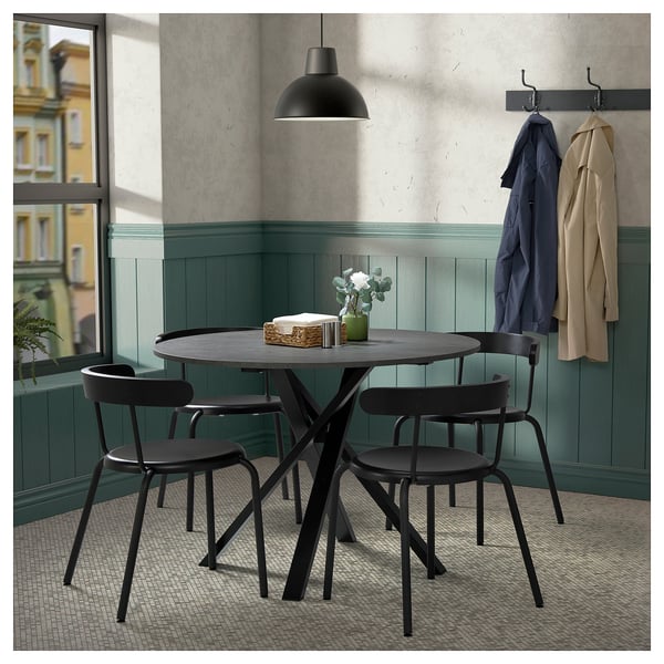 Modern dining area with MARIEDAMM black metal table and chairs, round tabletop.