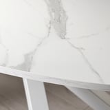 A modern, white, oval tabletop with sleek edges, supported by metal legs. Veins are visible across the surface, adding texture and elegance.