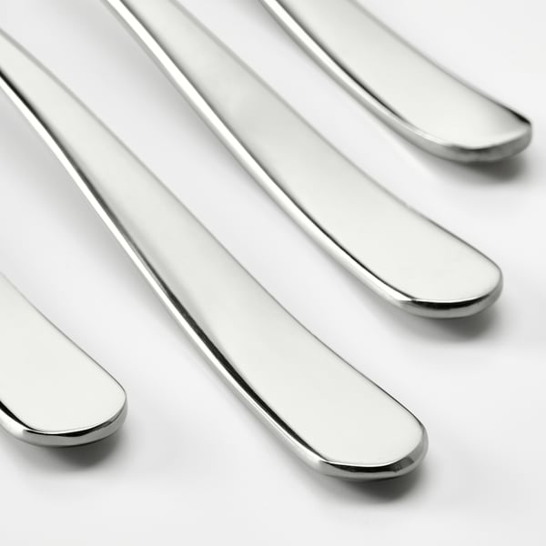 Four sleek, polished silver forks arranged closely together, highlighting their smooth, reflective surfaces and elegant curves.