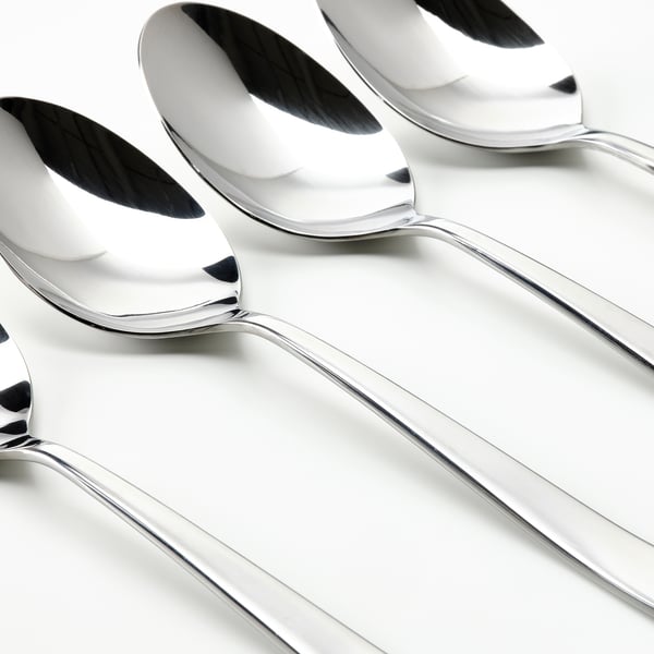 Four shiny, polished metallic spoons arranged neatly in a row, pristine surface reflecting light.