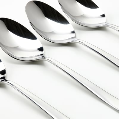 Four shiny, polished metallic spoons arranged neatly in a row, pristine surface reflecting light.