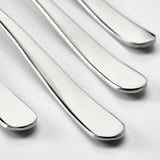 Four polished, stainless steel spoons are neatly arranged in a row, showcasing their sleek, reflective surfaces against a plain background.