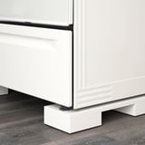 White adjustable appliance feet support kitchen equipment, ensuring proper height alignment with cabinets.