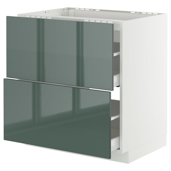 Modern green kitchen cabinet with white framework and drawers.