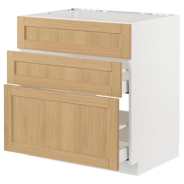 Depicts a white METOD kitchen cabinet with light wood veneer drawers, featuring three open drawers.