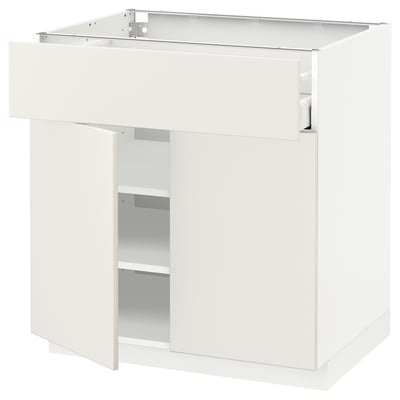 A white METOD kitchen cabinet with one open door and one drawer, featuring sleek modern design.