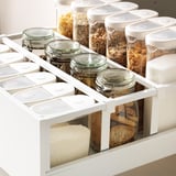 Clear jars in kitchen drawers with food, organized and accessible.