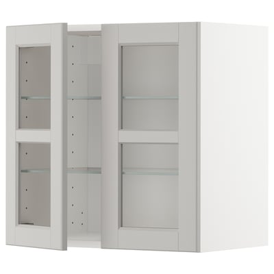 A white METOD kitchen cabinet with glass doors, containing adjustable shelves.