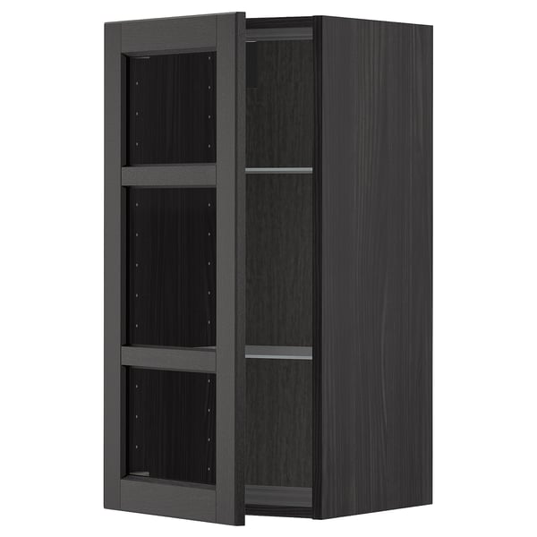 Black stained wooden kitchen cabinet with glass doors and shelves.