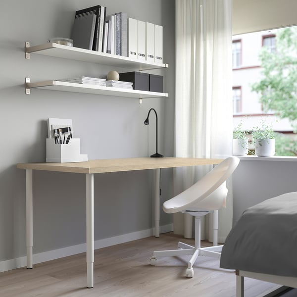 Modern pine desk MITTCIRKEL with adjustable legs, holding a chair under bookshelves.