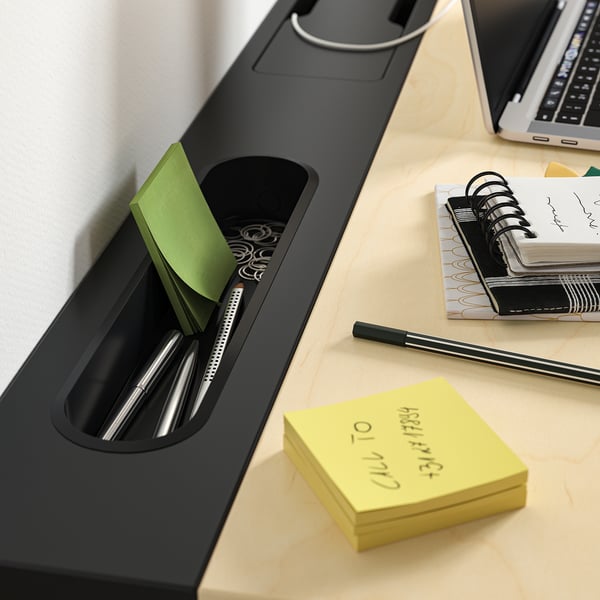 Organized desk setup with MITTZON desk, featuring pens, calculator, sticky notes, and laptop.