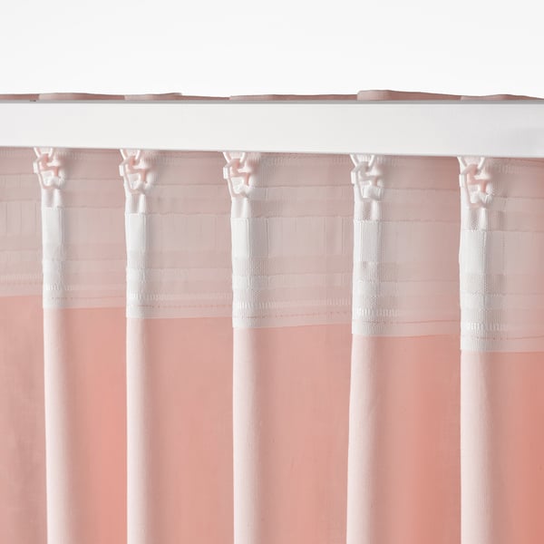 Sheer pink curtains with white bands hang from hooks, providing privacy and diffused light.