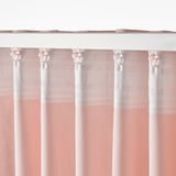 Sheer pink curtains with white bands hang from hooks, providing privacy and diffused light.