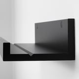 Black wall-mounted picture ledge, crafted from smooth fibreboard with a sleek paper foil finish. Ideal for displaying photos and art.