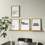 Modern wall-mounted shelf displays four motivational framed prints and a potted plant, providing both decoration and inspiration.