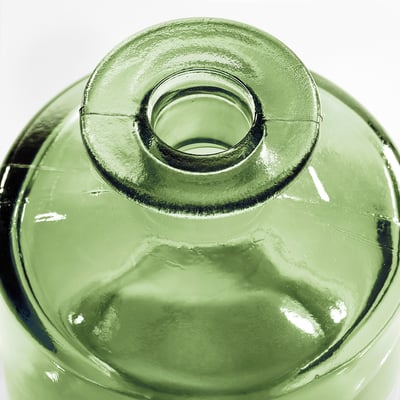 A green recycled glass vase named MYRMOSAIK. Its shape is cylindrical with a narrow neck and slightly textured appearance.