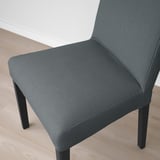 Close-up of modern grey upholstered chair on wood floor. High-quality fabric, sturdy legs, comfortable design.