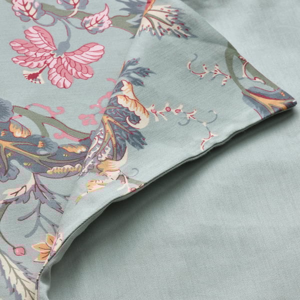 A neatly folded green fabric with intricate floral designs, highlighting its luxurious sateen weave and vibrant colors.