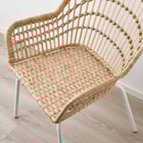 Wicker chair with bamboo back, elegant hand-woven design, white metal legs.