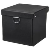 A black, square NIMM storage box with a lid and metal handle. Make of recycled paperboard.