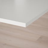 White tabletop on wooden floor; clean, modern design.