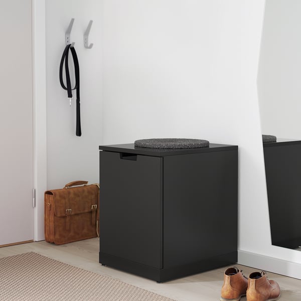 Black IKEA NORDLI drawers with cushion, bag, and boots.