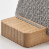 Wireless charging stand with smooth bamboo base and sleek metallic charger, exquisite design.