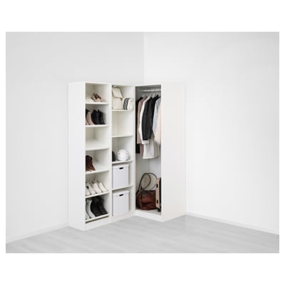 White corner wardrobe with shoes, clothes, and tennis racket.