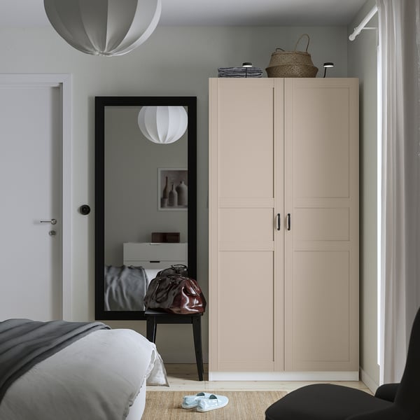 Minimalist bedroom with large beige PAX wardrobe, mirror, and grey quilt bed.
