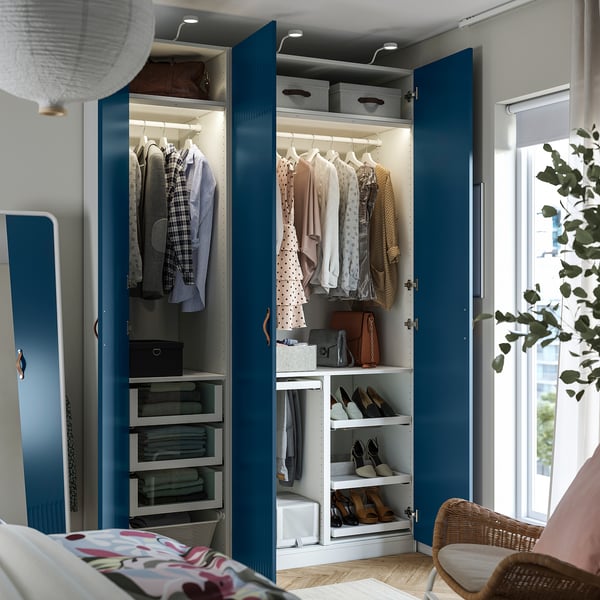 Open blue wardrobe showing clothes, shoes, and storage boxes, with integrated lighting.