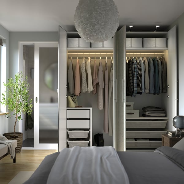Open wardrobe with clothes, drawers, and shelves. Interior lights illuminate the contents.