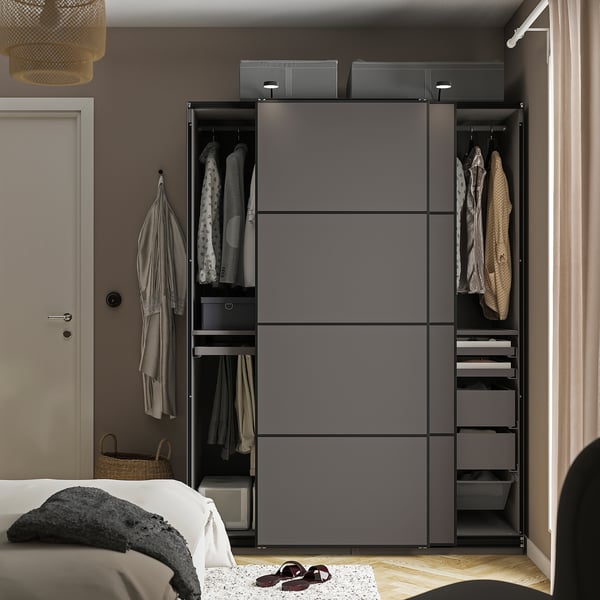 A modern bedroom a grey PAX wardrobe with hangers, shelves, and drawers, organizing clothes and accessories.