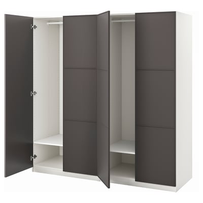An open white and black ikea PAX wardrobe with sliding doors, internal shelves, and a hanging rail.