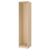 A light-colored wooden PAX wardrobe frame, standing upright and empty. Its rectangular with smooth edges and a simple, minimalist design.