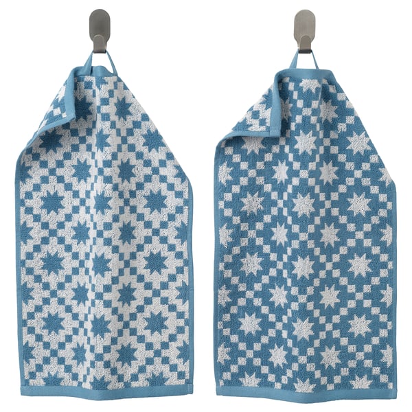 Two blue cotton towels with white star patterns hang side by side.
