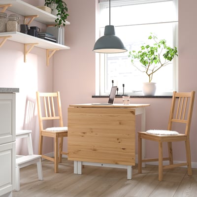 A white and light wood drop-leaf table, ideal for small spaces.