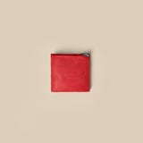 Foldable red bag, durable, eco-friendly. Recycled polyester. Pocket-sized, expands for shopping.
