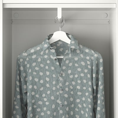 A polka dot shirt hangs on a hanger inside a gray wardrobe, demonstrating storage functionality of the PLATSA system.