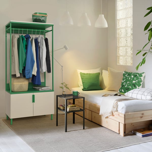 Modern PLATSA wardrobe with clothes, bed, and minimalist decor.