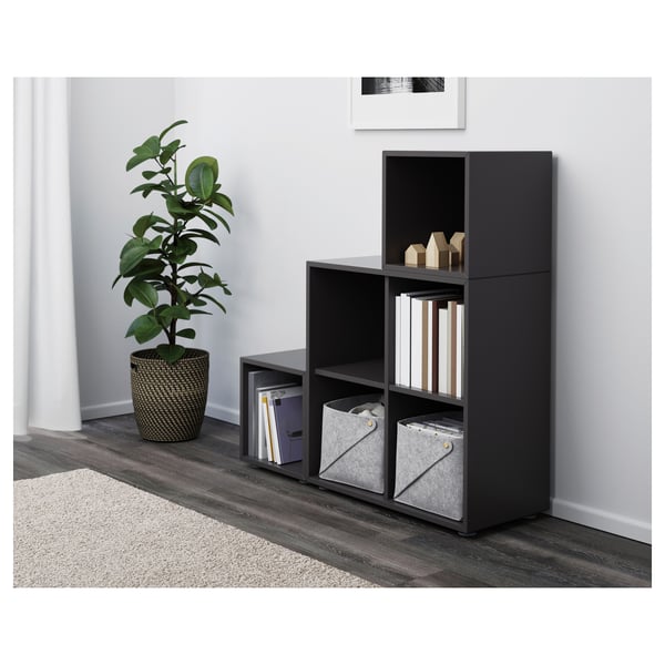 Black cube shelves with bins, books, decor, plant, rug