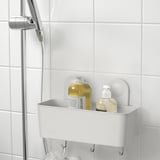 A RÅNEN bathroom organizer with suction cups, holding large shampoo and soap dispensers, plus three hooks below.
