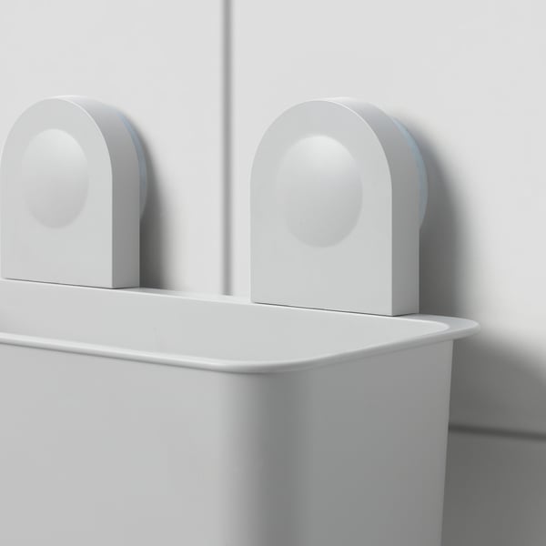 Two white RÅNEN bathroom storage baskets hang on a wall using suction cups, holding shampoo bottles.