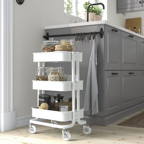 White RÅSKOG trolley with 3 shelves, small, fits under tables, holds jars.