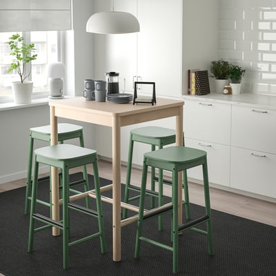 Small modern dining set with green bar stools and light wood table.