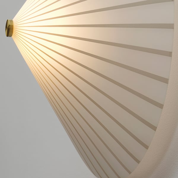 Elegant wall lamp with striped, translucent shade emits soft, diffused light.