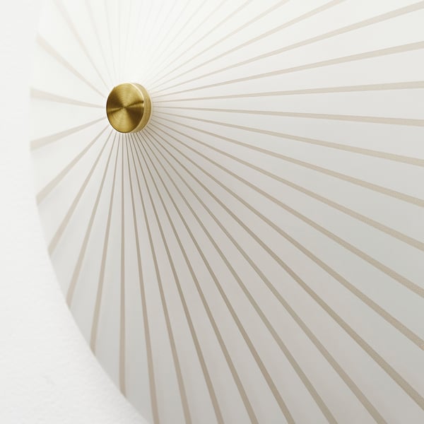 Modern wall lamp with gold centre, emitting soft, diffused light.