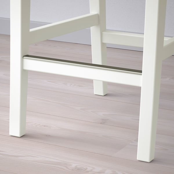 White wooden bar stool with metal footrest on light wooden floor. Sturdy and stylish design.