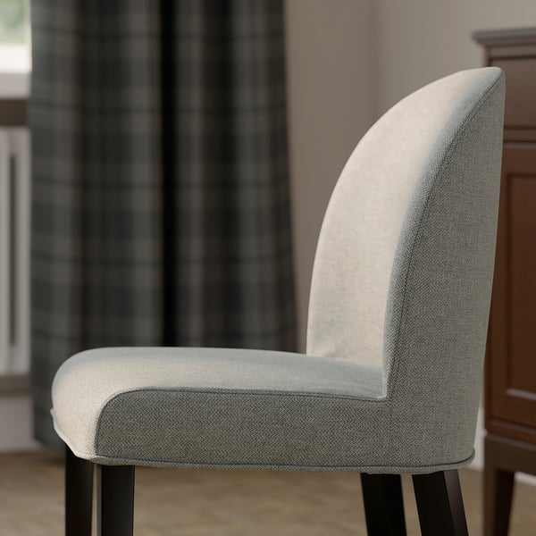 Modern, upholstered dining chair with cushioned seat and curved back. Light grey fabric, sturdy black legs. Comfortable and stylish.