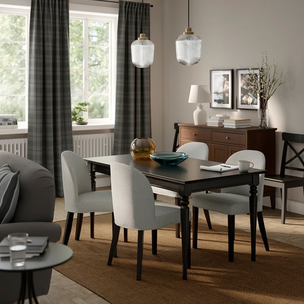 Cozy dining room with ROSENTORP chairs, table, hanging lamps, gray curtains, sofa, and sideboard.