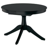 Black extendable dining table with round top and pedestal base, seats up to six.